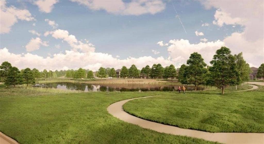 Expansive green space featuring a central pond, winding concrete walking paths, and mature trees