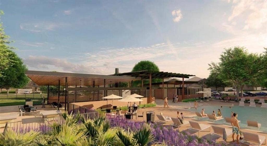 Outdoor community pool area featuring a paved sun deck, expansive shaded pavilion, built-in masonry grill station, and architectural pergola structures