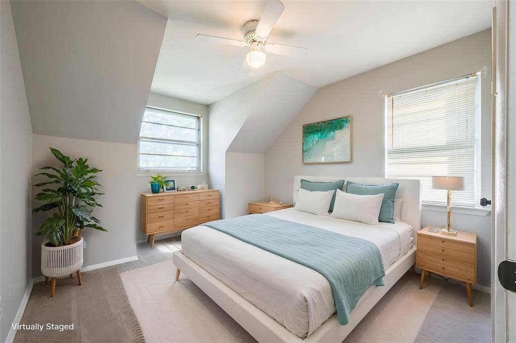 Vaulted ceiling featuring a central white light fixture with a multi-blade ceiling fan and dual windows with horizontal blinds