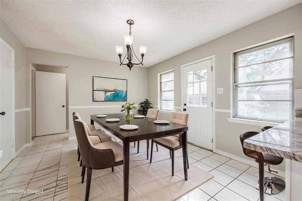Ceramic tile flooring, crown molding, chair rail molding, multi-light chandelier, and stone-finish countertop