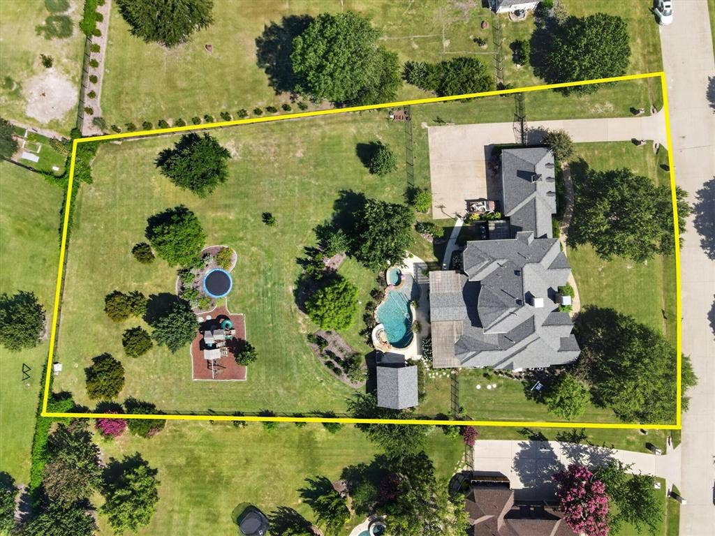 Expansive grounds featuring a swimming pool, integrated spa, detached structure, and mature landscaping