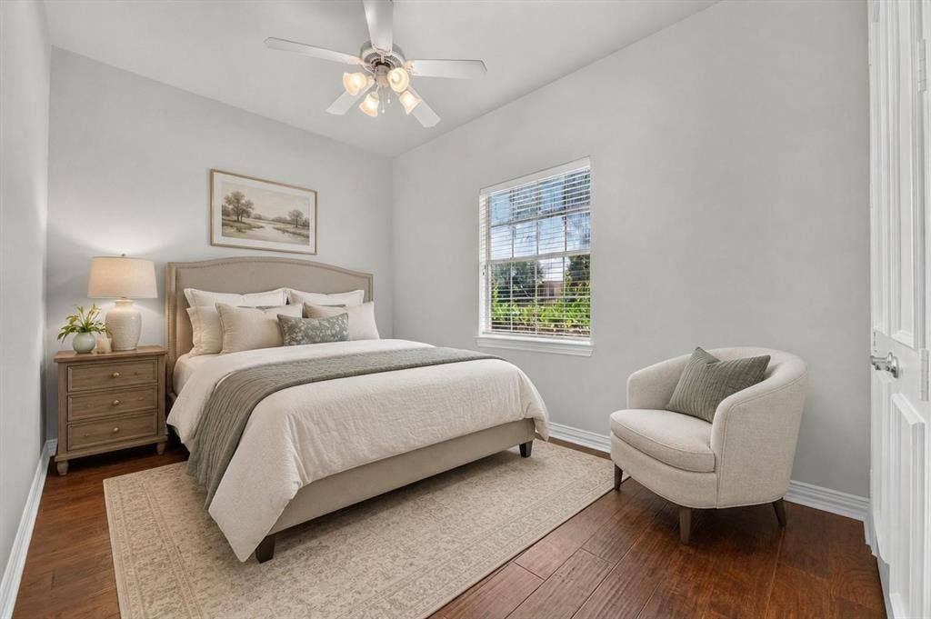 Bedroom featuring wood-finish flooring, a multi-light ceiling fan, and a window with blinds
