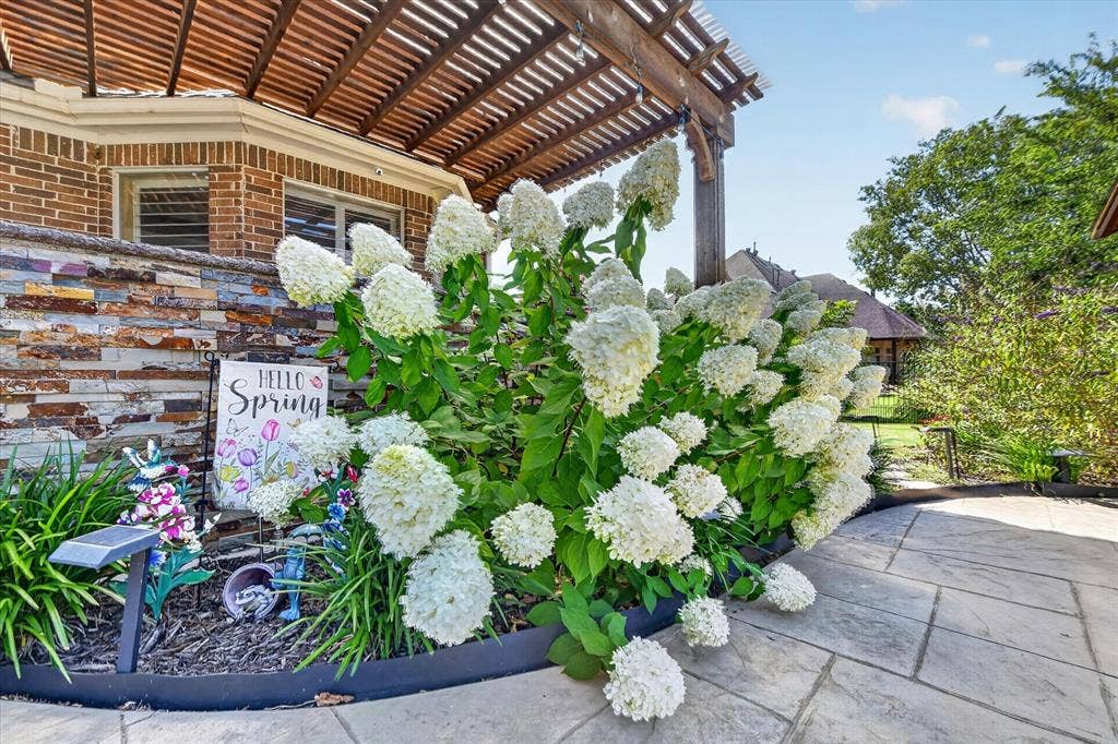 Patio featuring a stained wood pergola, natural stone veneer accent wall, and stone paver flooring