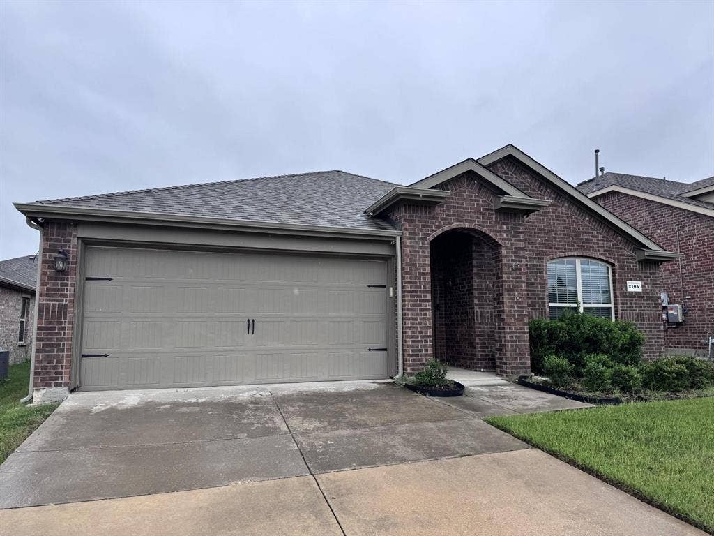 2105 Meadow Park Drive, Princeton, TX 75407 Brick exterior featuring an arched entryway, gabled roofline, concrete driveway, and a two-car garage