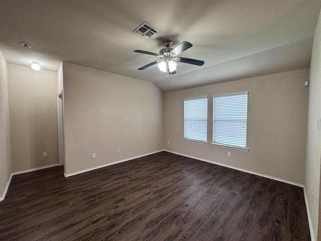 2105 Meadow Park Drive, Princeton, TX 75407 Room featuring wood-finish flooring, vaulted ceilings, dual windows with horizontal blinds, and a multi-light ceiling fan