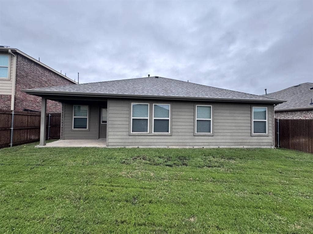 2105 Meadow Park Drive, Princeton, TX 75407 Rear exterior featuring a concrete covered patio, horizontal lap siding, asphalt shingle roof, and a fenced backyard