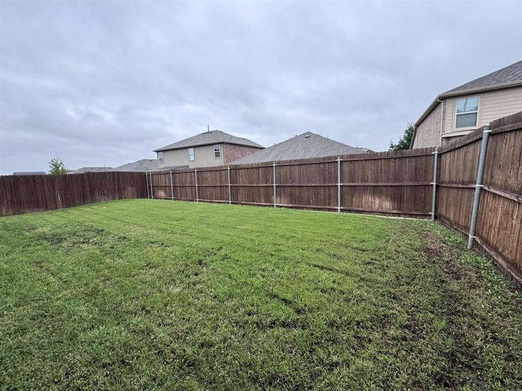 2105 Meadow Park Drive, Princeton, TX 75407 Backyard featuring a grass lawn enclosed by wood privacy fencing with metal posts