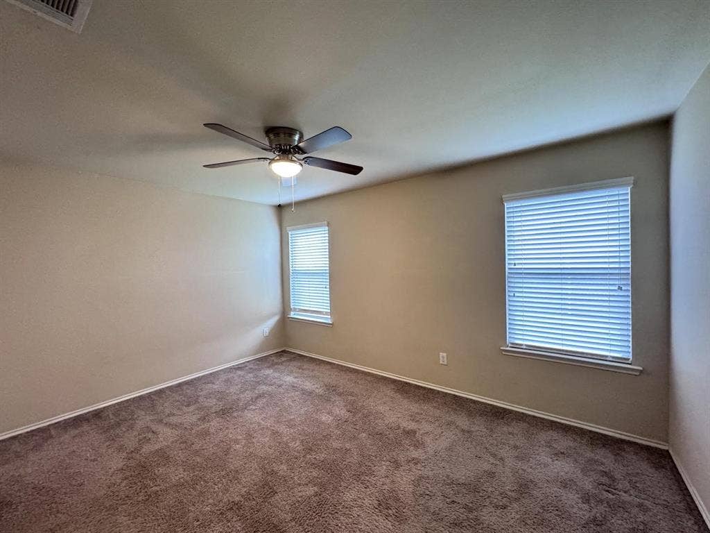 2105 Meadow Park Drive, Princeton, TX 75407 Neutral-toned walls, wall-to-wall carpeting, ceiling fan with integrated lighting, and windows featuring horizontal blinds