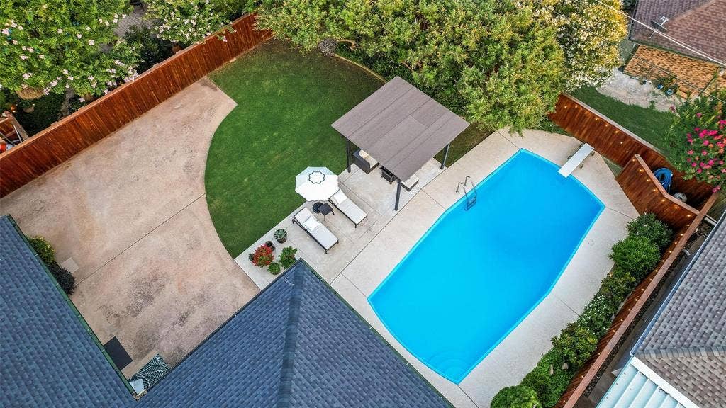 620 Cox Drive, Irving, TX 75062 Backyard featuring a concrete pool with a diving board, covered pergola, expansive concrete patio, and fenced perimeter