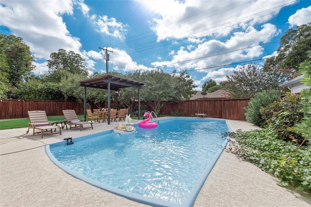 620 Cox Drive, Irving, TX 75062 In-ground swimming pool with concrete decking, covered pergola, and perimeter wood privacy fencing