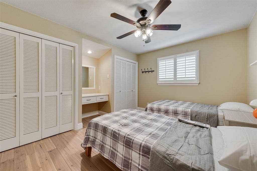 620 Cox Drive, Irving, TX 75062 Wood-finish flooring, louvered closet doors, built-in vanity, ceiling fan with integrated lighting, and plantation shutters