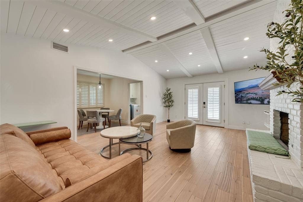 620 Cox Drive, Irving, TX 75062 Vaulted ceiling with exposed beams, recessed lighting, wood-finish flooring, and white-painted brick fireplace