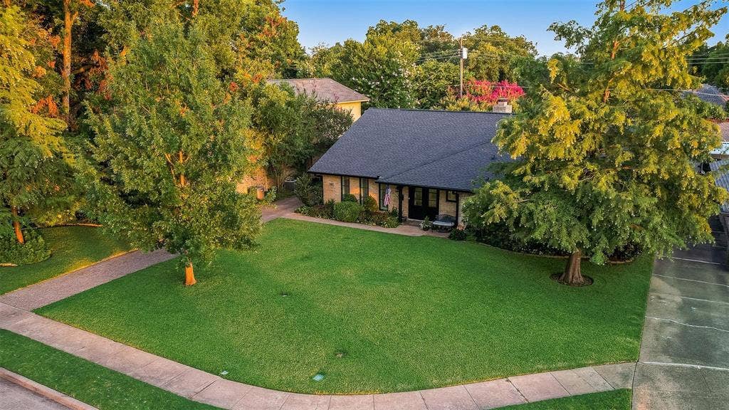 620 Cox Drive, Irving, TX 75062 Single-story residence featuring a pitched roof, expansive front lawn, mature trees, and a paved driveway