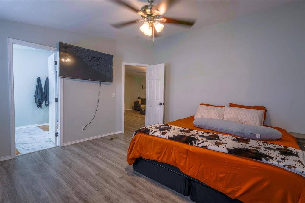 Wood-finish flooring, ceiling fan with integrated lighting, and interior six-panel doors