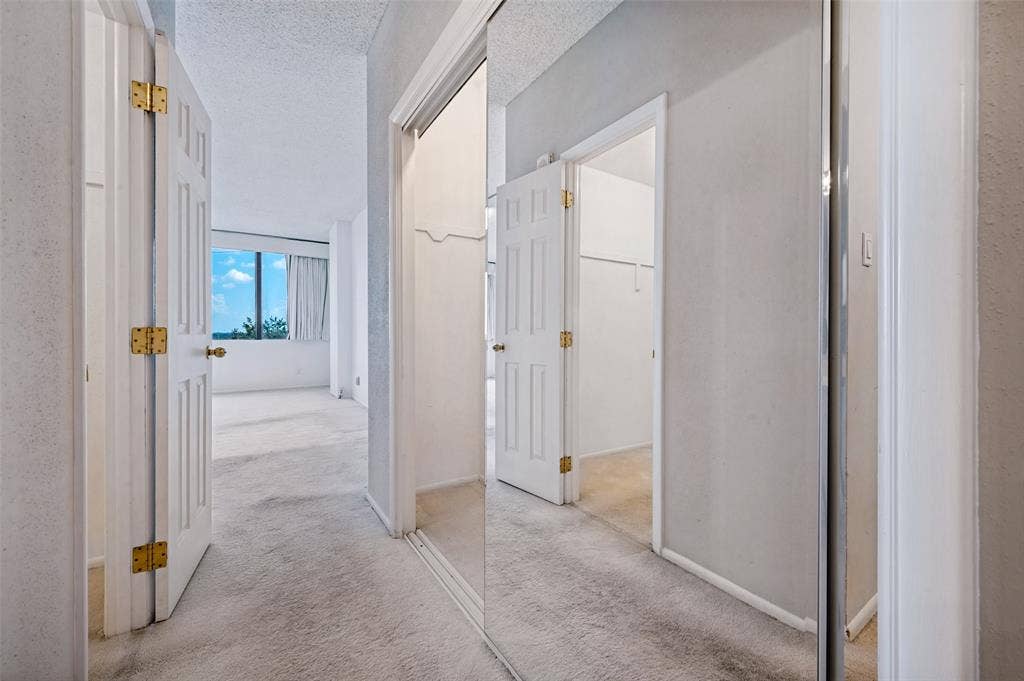 5200 Keller Springs Road, #522, Dallas, TX 75248 Floor-to-ceiling mirrored sliding closet doors, multi-panel interior doors with brass-finish hardware, and wall-to-wall carpeting