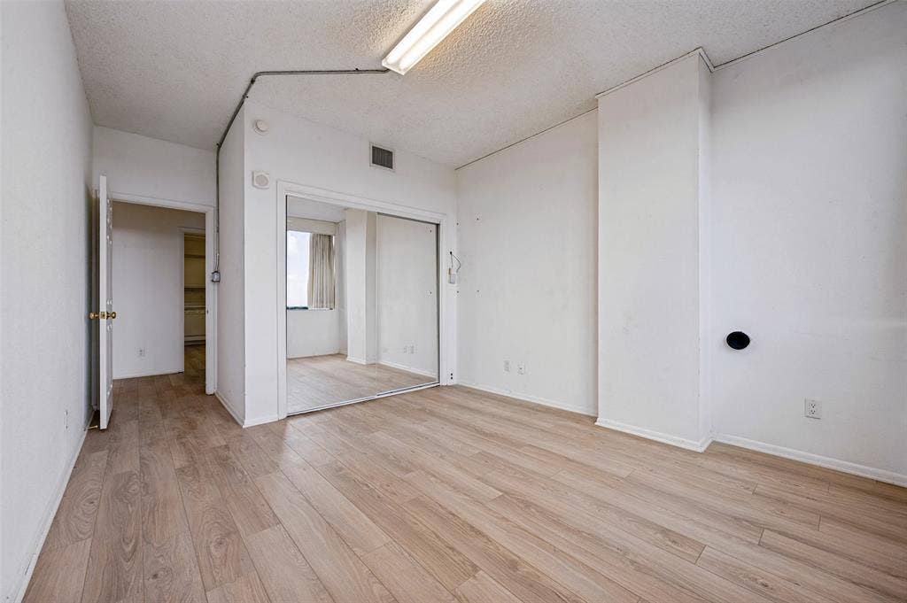 5200 Keller Springs Road, #522, Dallas, TX 75248 Wood-finish flooring, sliding mirror-panel closet doors, and interior doorway access