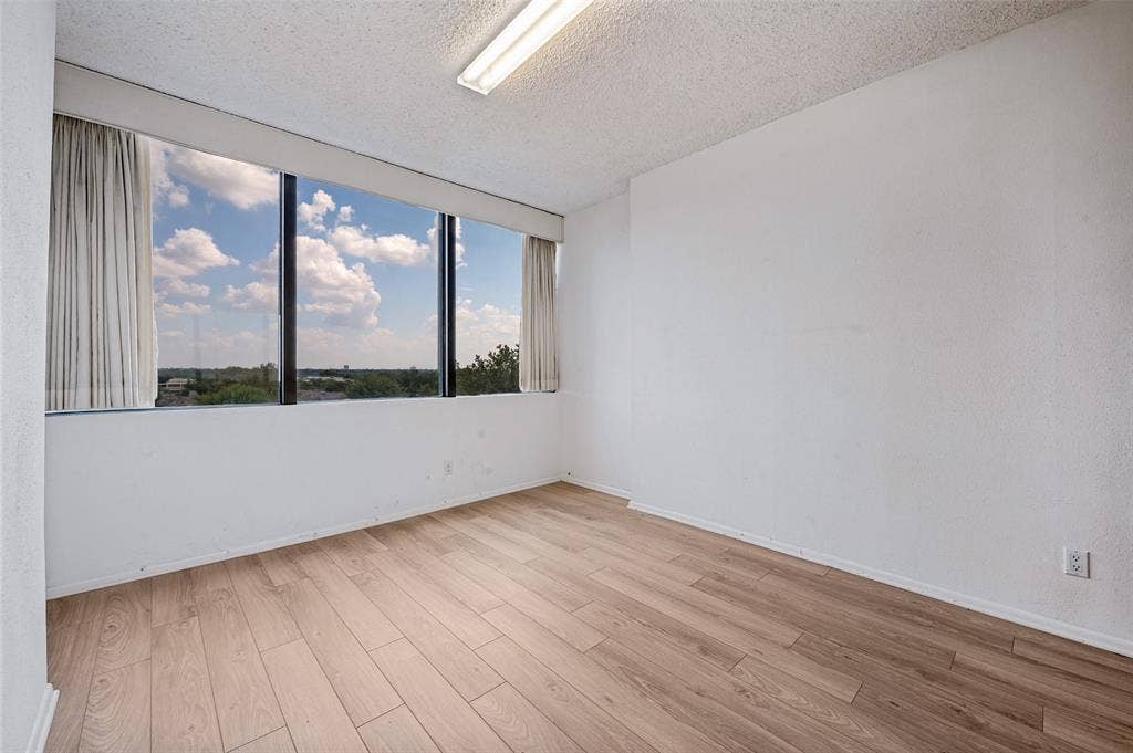5200 Keller Springs Road, #522, Dallas, TX 75248 Expansive floor-to-ceiling windows featuring natural lighting and wood-finish flooring