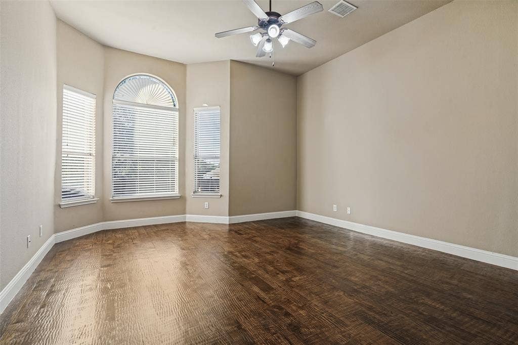 1380 Riverside Oaks Drive, Rockwall, TX 75087 Room featuring wood-finish flooring, a bay window with an arched transom, and a ceiling fan with integrated lighting