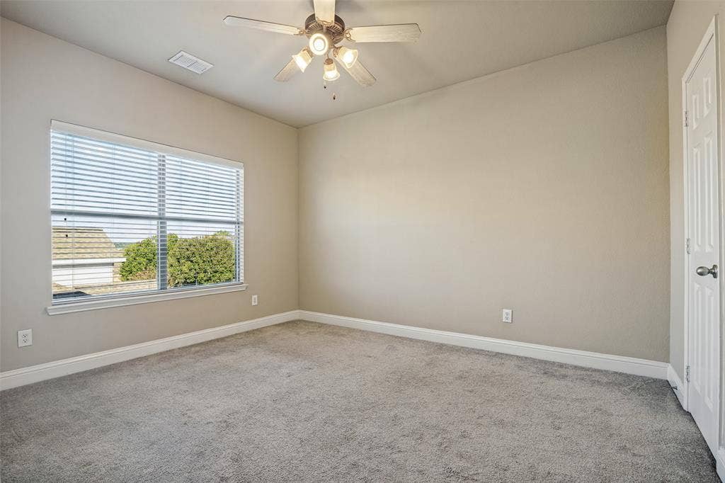 1380 Riverside Oaks Drive, Rockwall, TX 75087 Room featuring neutral wall tones, plush wall-to-wall carpeting, a multi-blade ceiling fan with integrated lighting, and a window with horizontal blinds