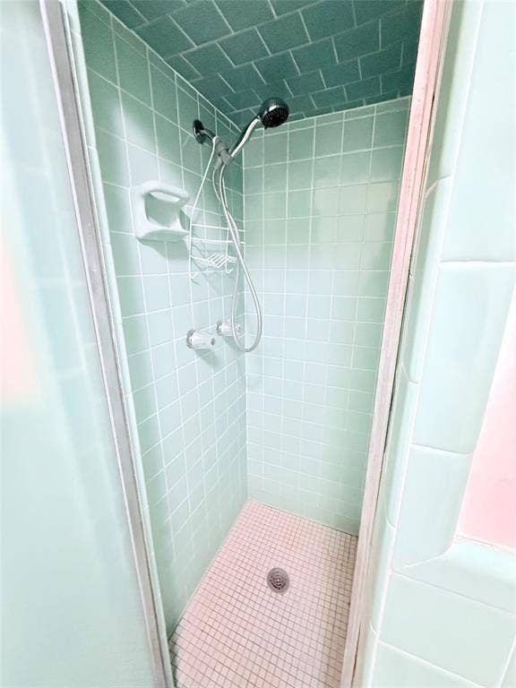 1500 S Houston, Denison, TX 75020 Shower stall featuring square ceramic wall tiling, ceiling tile finish, handheld showerhead, and integrated soap dish