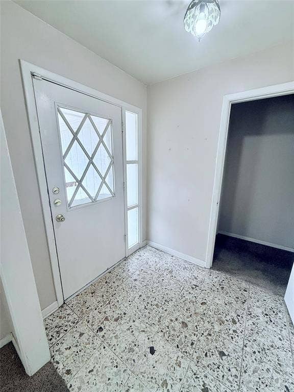 1500 S Houston, Denison, TX 75020 Entryway featuring diamond-pattern glass door inlay, vertical side-light window, and large-format aggregate flooring