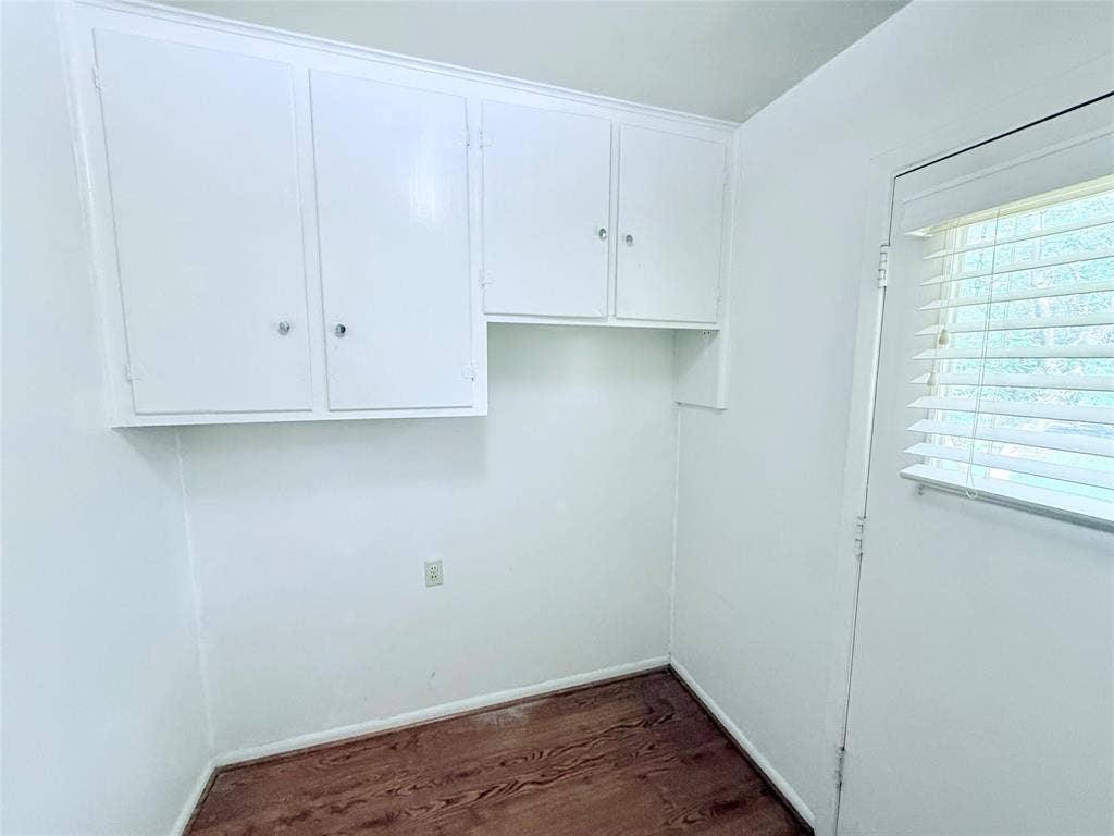 1500 S Houston, Denison, TX 75020 White built-in upper cabinetry, wood-finish flooring, and horizontal window blinds