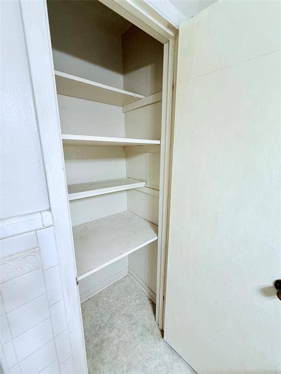 1500 S Houston, Denison, TX 75020 Built-in storage closet featuring multiple fixed shelving tiers and a solid panel door