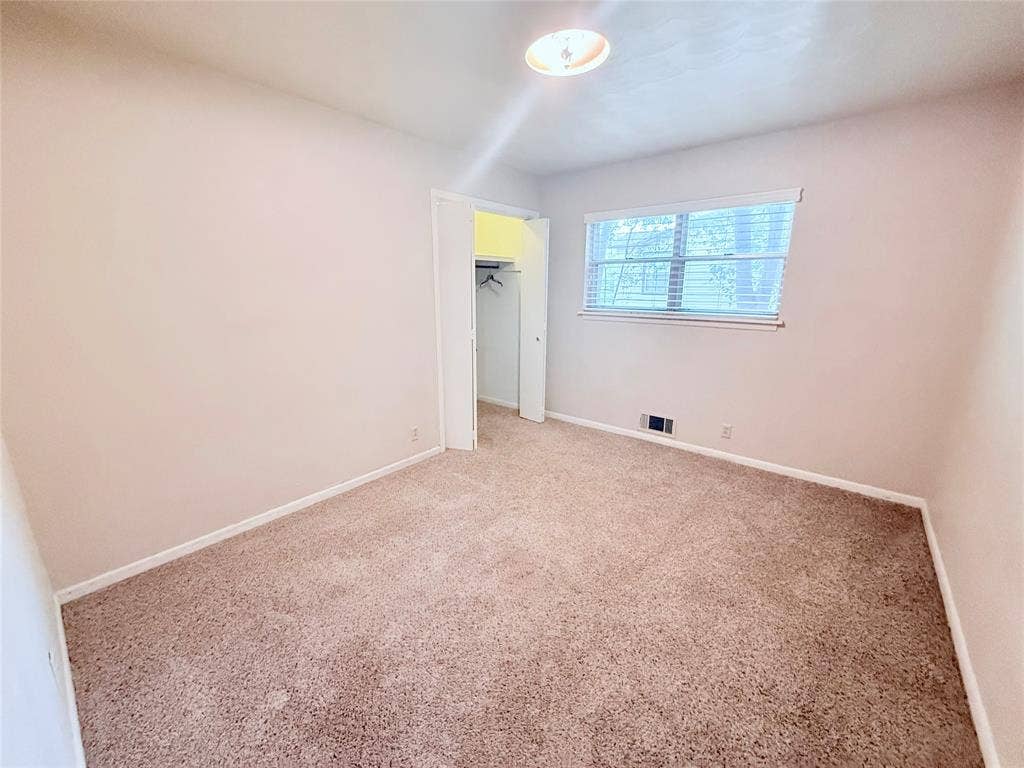 1500 S Houston, Denison, TX 75020 Neutral-toned interior featuring wall-to-wall carpeting, a reach-in closet with double doors, and a double-hung window