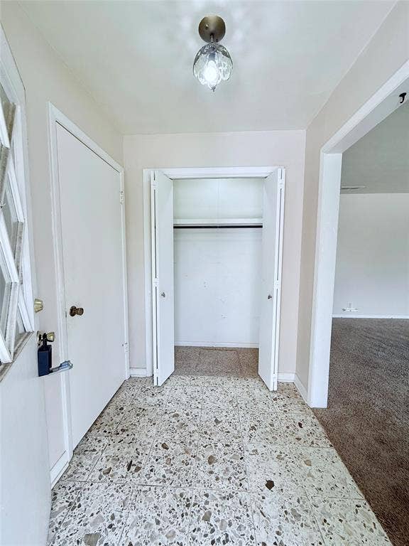1500 S Houston, Denison, TX 75020 Entryway featuring terrazzo flooring, a multi-panel door with decorative glass inlay, and a built-in closet with double bifold doors