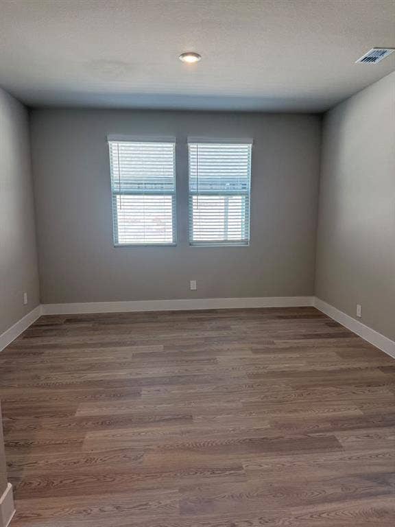 1313 Winters Way, Princeton, TX 75071 Interior room featuring neutral-toned wall paint, wood-finish flooring, and two windows with horizontal blinds