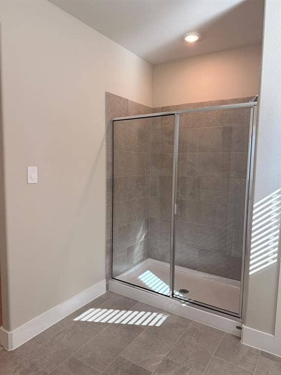 1313 Winters Way, Princeton, TX 75071 Walk-in shower featuring a sliding glass door, neutral-toned tiled surround, and matching tiled flooring