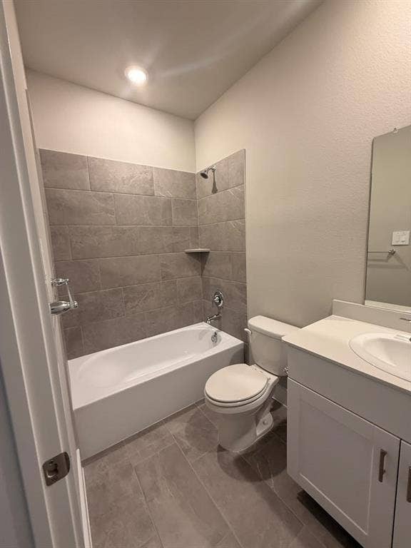 1313 Winters Way, Princeton, TX 75071 Bathroom featuring a white bathtub, grey tile wall surround, grey floor tiling, vanity with a solid-surface countertop, and a built-in mirror