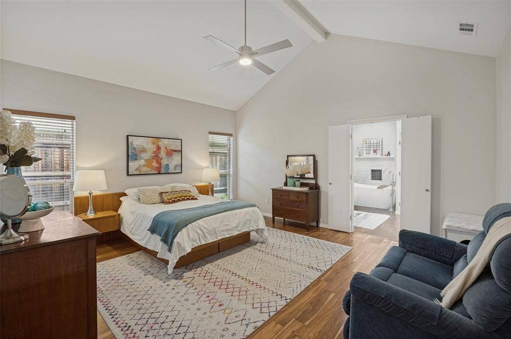 Spacious primary bedroom with sitting area and vaulted ceilings