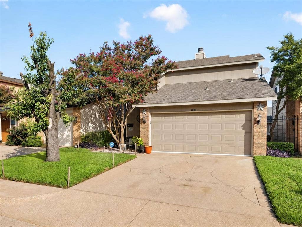 2851 Ursa Circle, Garland, TX 75044 Two-story exterior featuring a mix of brick and siding, concrete driveway, attached two-car garage, and established landscaping