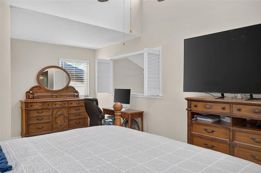 2851 Ursa Circle, Garland, TX 75044 Vaulted ceiling with an integrated ceiling fan and interior louvered shutters opening to an interior space