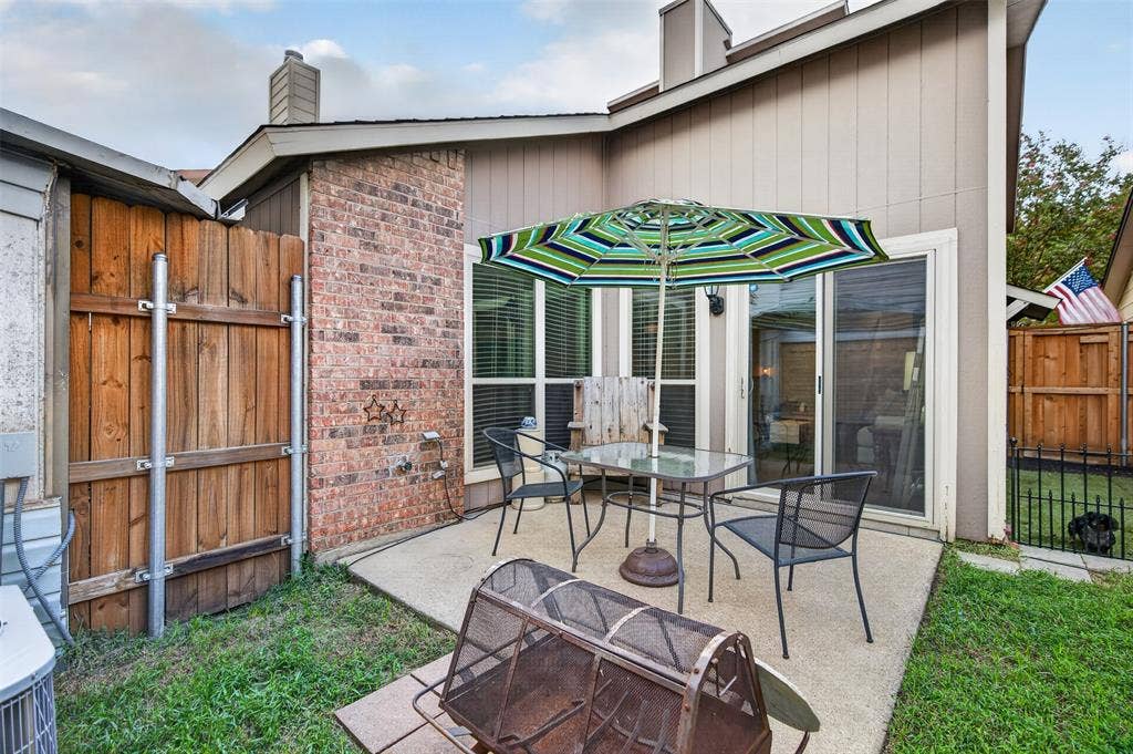 2851 Ursa Circle, Garland, TX 75044 Concrete patio featuring a brick masonry accent wall, sliding glass door, and wood-panel privacy fencing