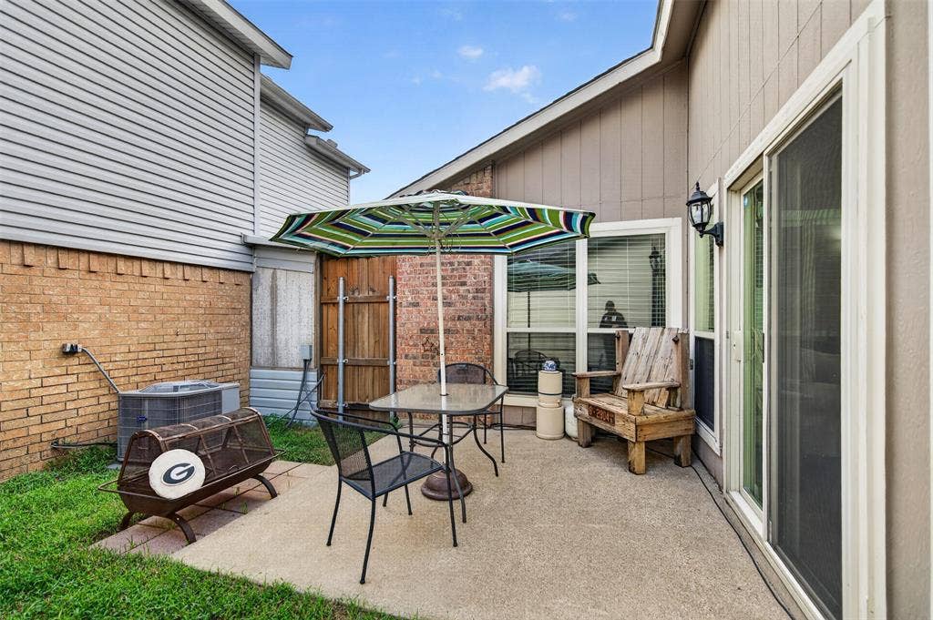 2851 Ursa Circle, Garland, TX 75044 Concrete patio featuring a brick masonry accent wall, sliding glass door, and wood-panel privacy fencing