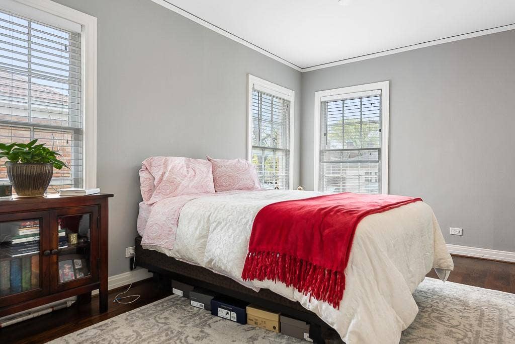 Room with dark wood-finish flooring, neutral wall coloring, and multiple windows with white trim