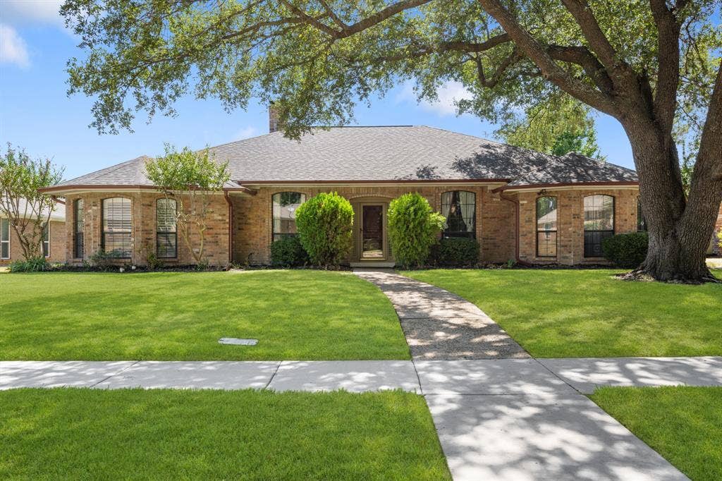2510 Buttercup Drive, Richardson, TX 75082 Beautifully maintained 4-bedroom, 3-bath home showcasing timeless brick architecture, mature trees, and beautifully manicured landscaping. The inviting front entry, expansive lawn, and charming curb appeal create a warm and welcoming first impression.