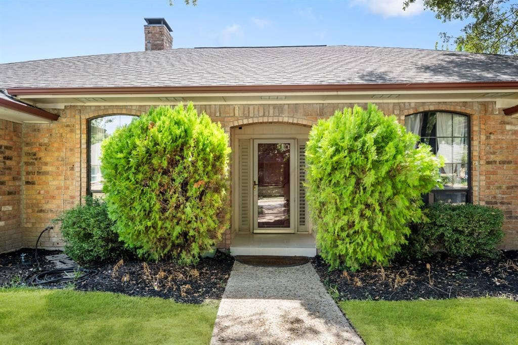 2510 Buttercup Drive, Richardson, TX 75082 Charming front entry highlighted by classic brick detailing, mature manicured shrubs, and thoughtfully landscaped flower beds. A welcoming walkway leads to the inviting entry, creating a polished and well-maintained first impression.