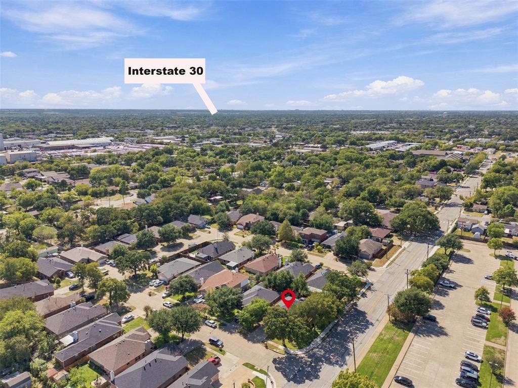873 Hope Lane, Irving, TX 75061 Aerial perspective showing a residential property with a shingle roof and mature canopy trees