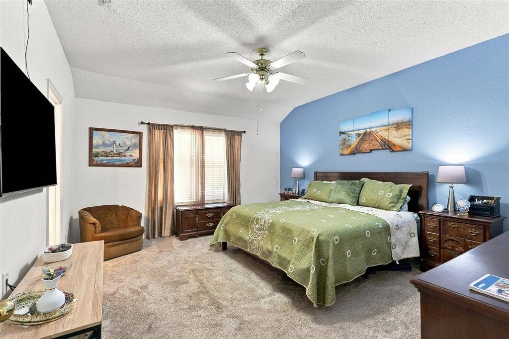 873 Hope Lane, Irving, TX 75061 Vaulted ceiling with a central multi-blade ceiling fan and wall-to-wall carpeting