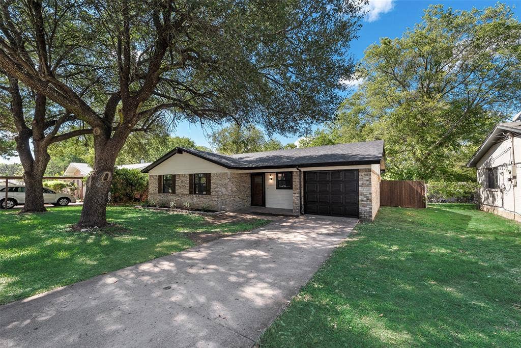1238 Neptune Drive, Cedar Hill, TX 75104 Single-story residence featuring a stone and siding exterior, asphalt shingle roof, attached garage, and mature trees on the lot