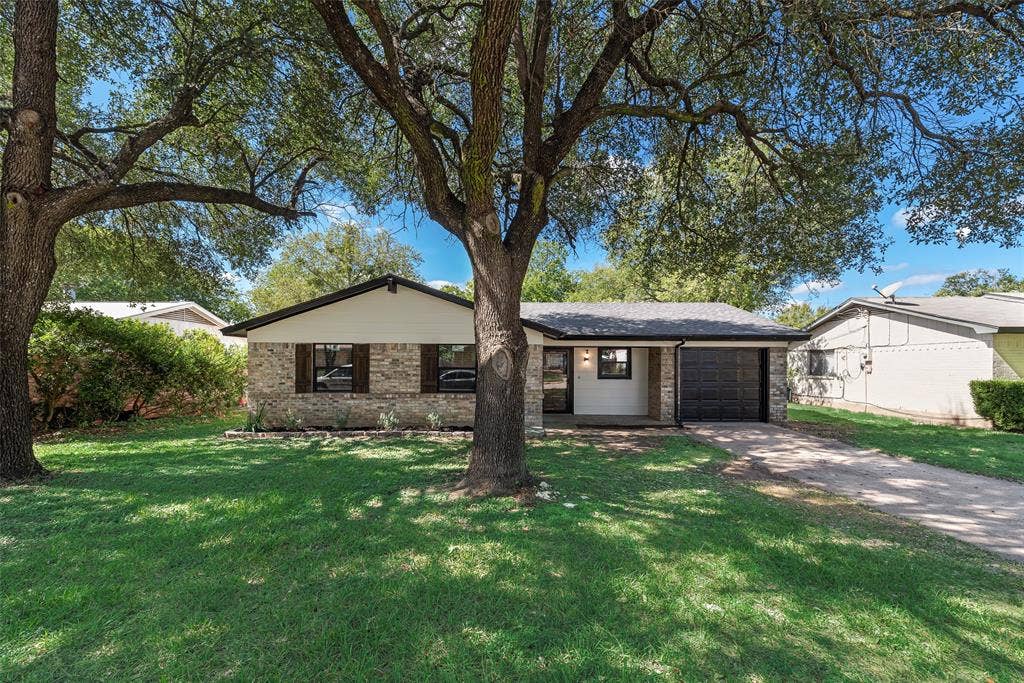1238 Neptune Drive, Cedar Hill, TX 75104 Single-story exterior featuring stone veneer siding, mature shade trees, attached single-car garage, and concrete driveway
