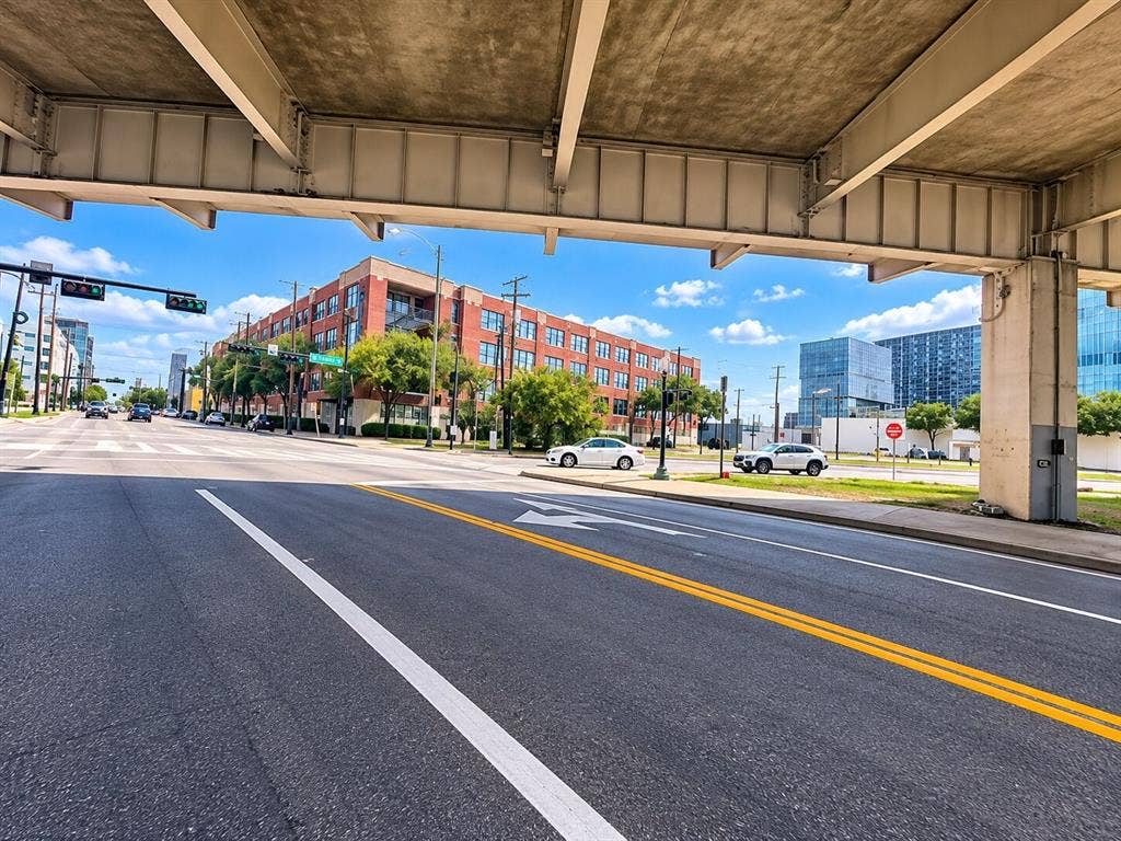 2502 Live Oak Street, #110, Dallas, TX 75204 Multi-story brick commercial building featuring multi-pane windows and a concrete overpass structure