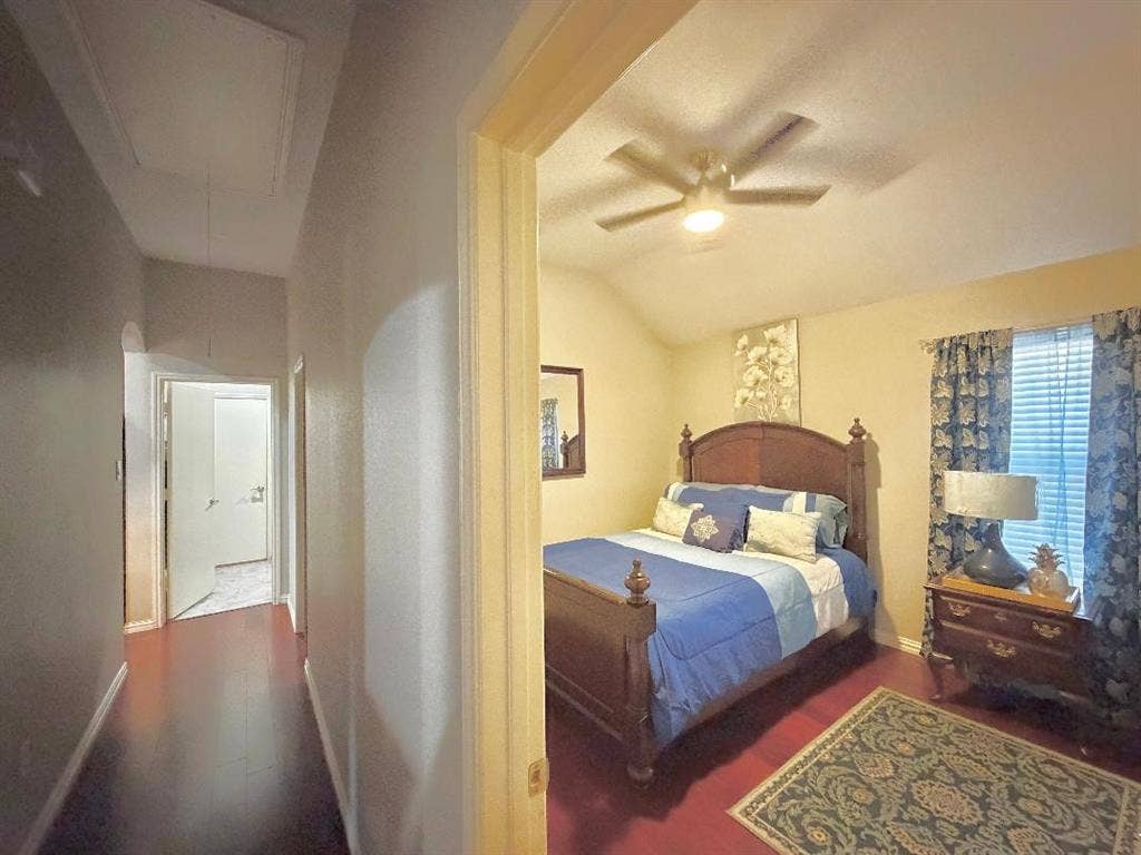 Vaulted ceilings, wood-finish flooring, and a ceiling fan with integrated lighting