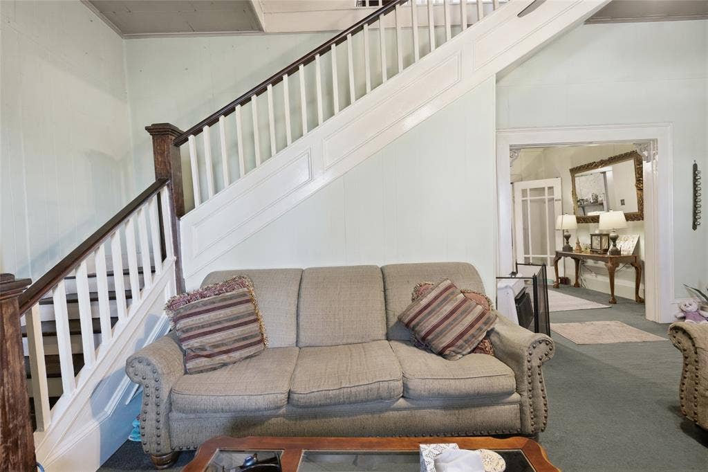 2309 Jones Street, Greenville, TX 75401 Open staircase featuring white balusters, stained-wood newel posts, and decorative paneling