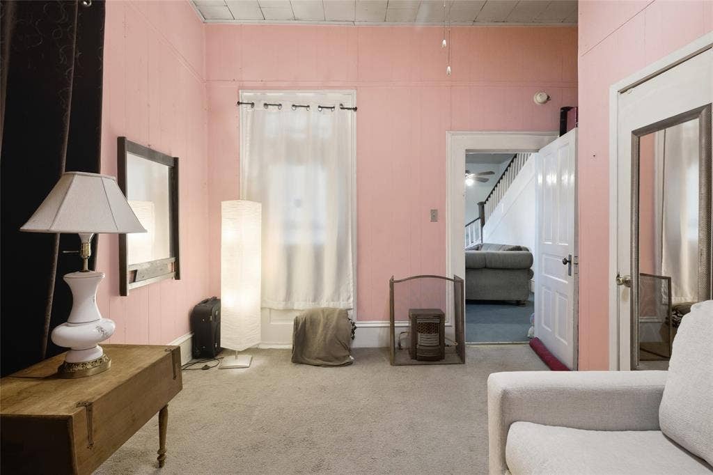 2309 Jones Street, Greenville, TX 75401 Interior room featuring neutral carpeting, a tiled ceiling, a multi-panel door with metallic hardware, and a tall window with decorative molding