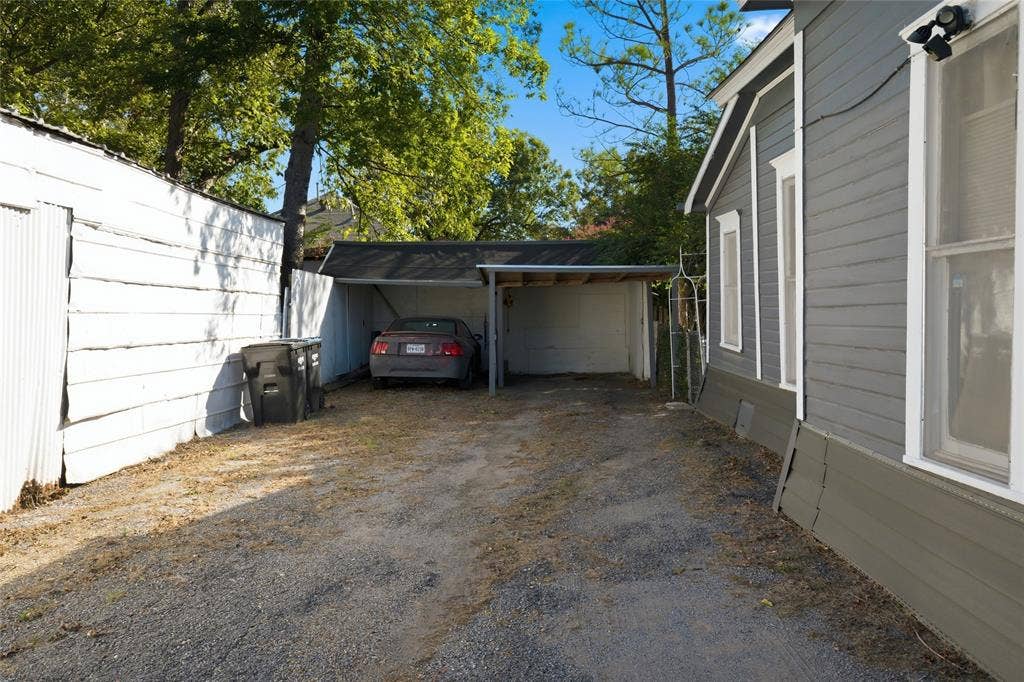 2309 Jones Street, Greenville, TX 75401 Exterior gravel driveway featuring a covered carport and horizontal lap siding
