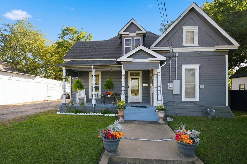 2309 Jones Street, Greenville, TX 75401 Gabled roofline exterior featuring lap siding, an expansive covered front porch, decorative porch columns, and a concrete walkway